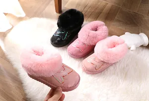Detailansicht von rosa und schwarzen Kinder-Schneestiefeln mit dickem Fellfutter.
