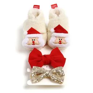 Detailansicht der Weihnachts-Babyschuhe aus Fleece mit Weihnachtsmann und Schleifen.