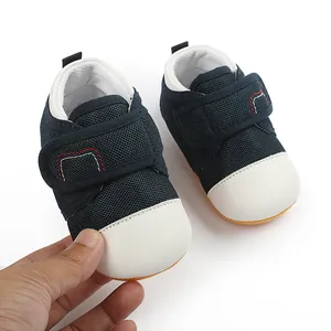 Close-up of navy blue mesh baby walking shoes with white toe cap and soft anti-slip sole