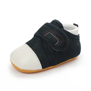 Close-up of navy blue mesh baby walking shoe with white toe and anti-slip rubber sole