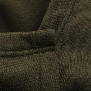 Close-up macro detail showing thick olive green fabric and stitching of men's cloak
