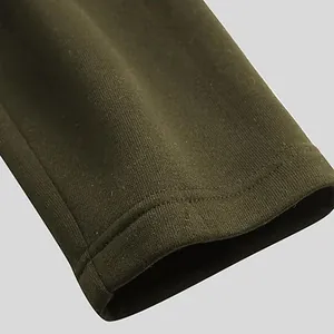 Close-up view of the durable double-stitched sleeve cuff on an olive green men's winter coat