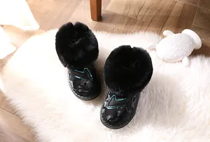 Nahaufnahme schwarzer Kinder-Schneestiefel mit Kunstpelz und dekorativem Seitenmuster