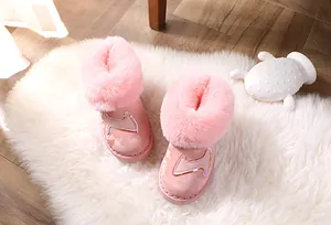 Rosa Schneestiefel für Kinder mit weichem Kunstfellfutter auf weißem Teppich