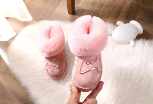 Nahaufnahme von rosa Kinder-Schneestiefeln mit Plüschfellbesatz und Camouflage-Muster
