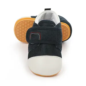 Close-up detail of navy blue mesh baby walking shoes with non-slip yellow rubber soles
