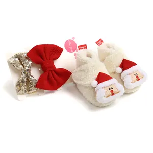 Detailansicht des Baby-Weihnachtsgeschenksets mit weißen Weihnachtsstiefeln und Schleifen
