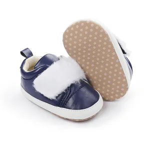 Navy blue infant walking shoes with white faux fur trim and non-slip dotted soft sole