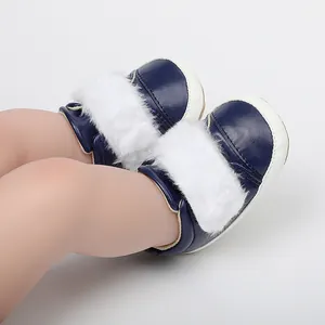 Close-up of navy blue baby winter shoes with soft white faux fur trim and white soles