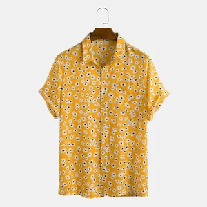 Gedetailleerd overzicht van geel shirt met korte mouwen en witte madeliefjesbloemen