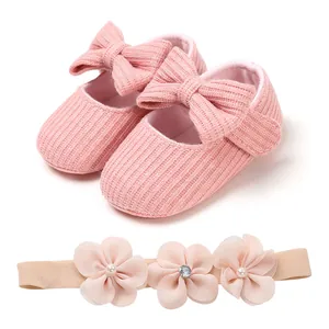 Soft pink knitted baby shoes with large bows and matching floral headband set