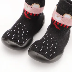 Detail of thick baby walking sock shoes with cute bear pattern and rubber sole.