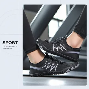 Zapatillas negras de vadeo para exteriores en un gimnasio sobre una cinta de correr