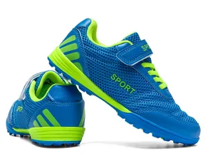 Detail view of breathable blue mesh kids soccer shoes with lime green Velcro straps.