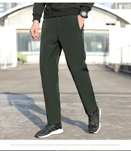 Lower body view of men's dark green nylon sports trousers for outdoor activities