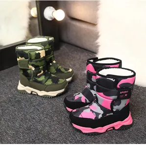 Vista detallada de dos pares de botas de nieve de camuflaje para niños en verde y rosa.