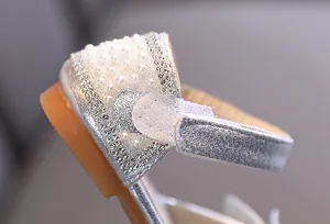 Macro detail of girl's princess shoe with rhinestones, pearls and velcro strap