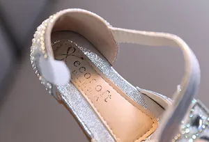 Close-up detail of rhinestone embellishments on girls' silver princess dance shoes