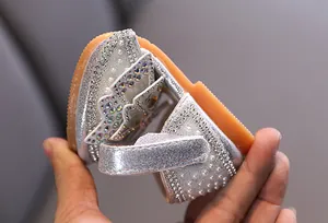 Detail view showing sparkling rhinestones and pearls on silver girl's princess shoe