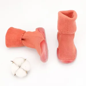 Detail view of orange baby winter sock shoes with warm knit fabric and non-slip soles.
