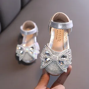 Sparkling silver girls' Mary Janes with a large rhinestone bow for princess dance performances