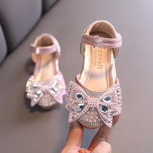 Elegant pink girls' princess shoes featuring a large sparkling rhinestone bow and pearls