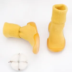 Detail view of yellow knit baby sock shoes with soft soles and warm lamb wool lining