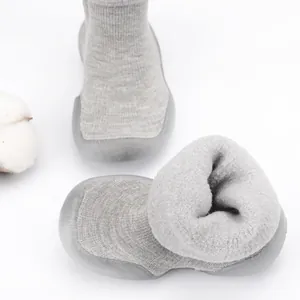 Detailed macro view showing soft lamb wool interior of grey knitted baby sock shoes