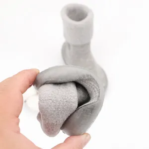 Close-up showing the extreme flexibility and soft grey lamb wool lining of baby sock shoes