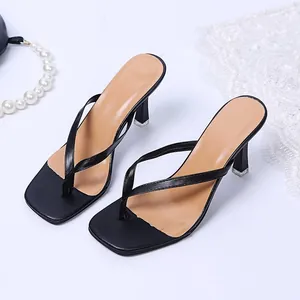 Detailoverzicht van zwarte teensandalen met hoge hak en een vierkante neus