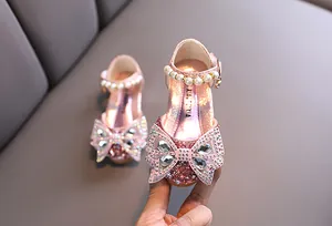 Detalle de cerca de zapatos de princesa rosas brillantes para niñas con lazo de diamantes