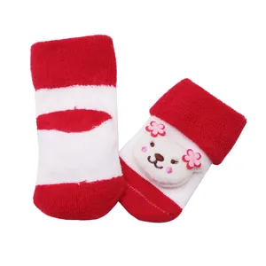 Vue détaillée de chaussettes bébé en éponge à rayures rouges avec un ours en peluche.