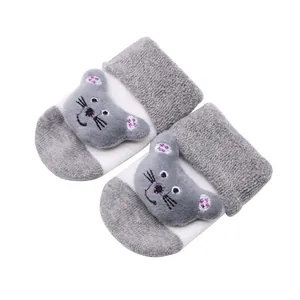 Vue détaillée des chaussettes antidérapantes bébé grises avec chat en peluche 3D.