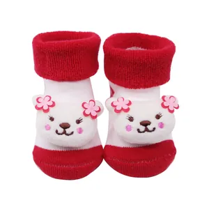 Gros plan détaillé de chaussettes épaisses rouge et blanc pour bébé avec ourson en peluche
