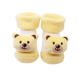 Gros plan de chaussettes de sol pour bébé jaunes avec motif d'ours et peluche épaisse