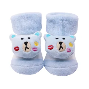 Gros plan de chaussettes bleues pour bébé avec têtes d'ours en peluche 3D et éponge