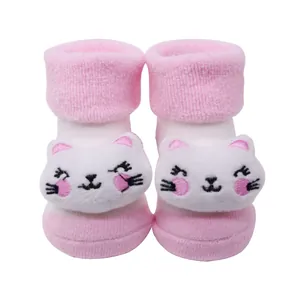 Détail rapproché de chaussettes en éponge roses pour bébé avec une poupée chat 3D