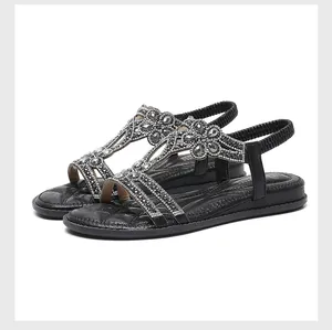 Detailed view of women's black casual flat sandals with floral rhinestone T-strap