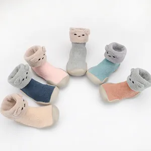 Cute cartoon bear baby sock shoes with non-slip soles in various colors.