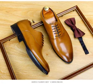 Gros plan de chaussures Oxford en cuir marron clair associées à un nœud papillon.