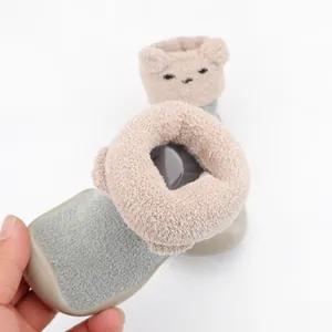 Close-up of fuzzy coral fleece baby indoor sock shoe with cute cartoon bear ear design