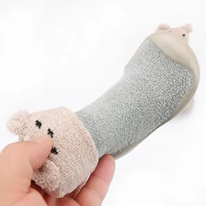 Detail view of warm baby sock shoes with cute cartoon bear design and soft soles