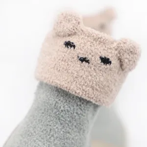 Close-up detail of cute cartoon animal face on soft coral fleece warm baby sock shoes