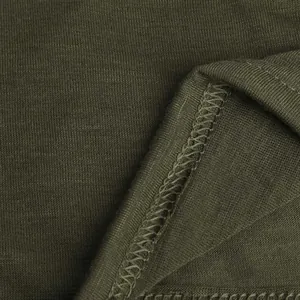 Gros plan du tissu tricoté vert olive et de la couture de surjet pour vêtement d'intérieur.