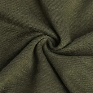 Primer plano de la textura de tela jersey suave verde oliva con pliegues en espiral.