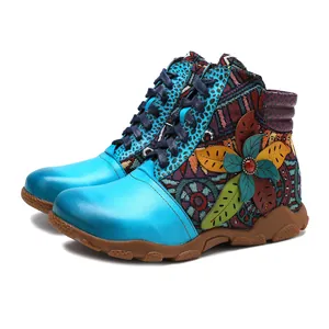 Detail view of colorful bohemian ankle boots with ethnic patterns and leather leaf decor.