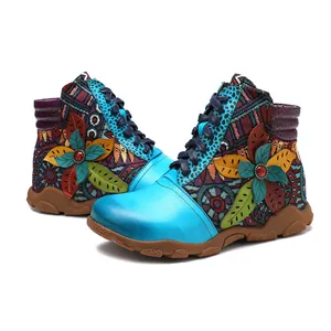 Detailed view of bohemian style blue leather boots with colorful floral appliqués.