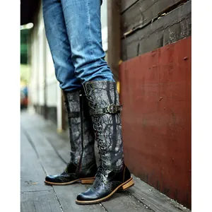 Vista detallada de botas altas de mujer estilo biker con cordones y motivos florales