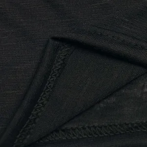 Primer plano de tela de punto negra transpirable con costura de remallado duradera.