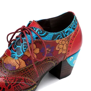 Close-up of vintage ethnic floral patchwork high heels with detailed stitching and lace-up.
